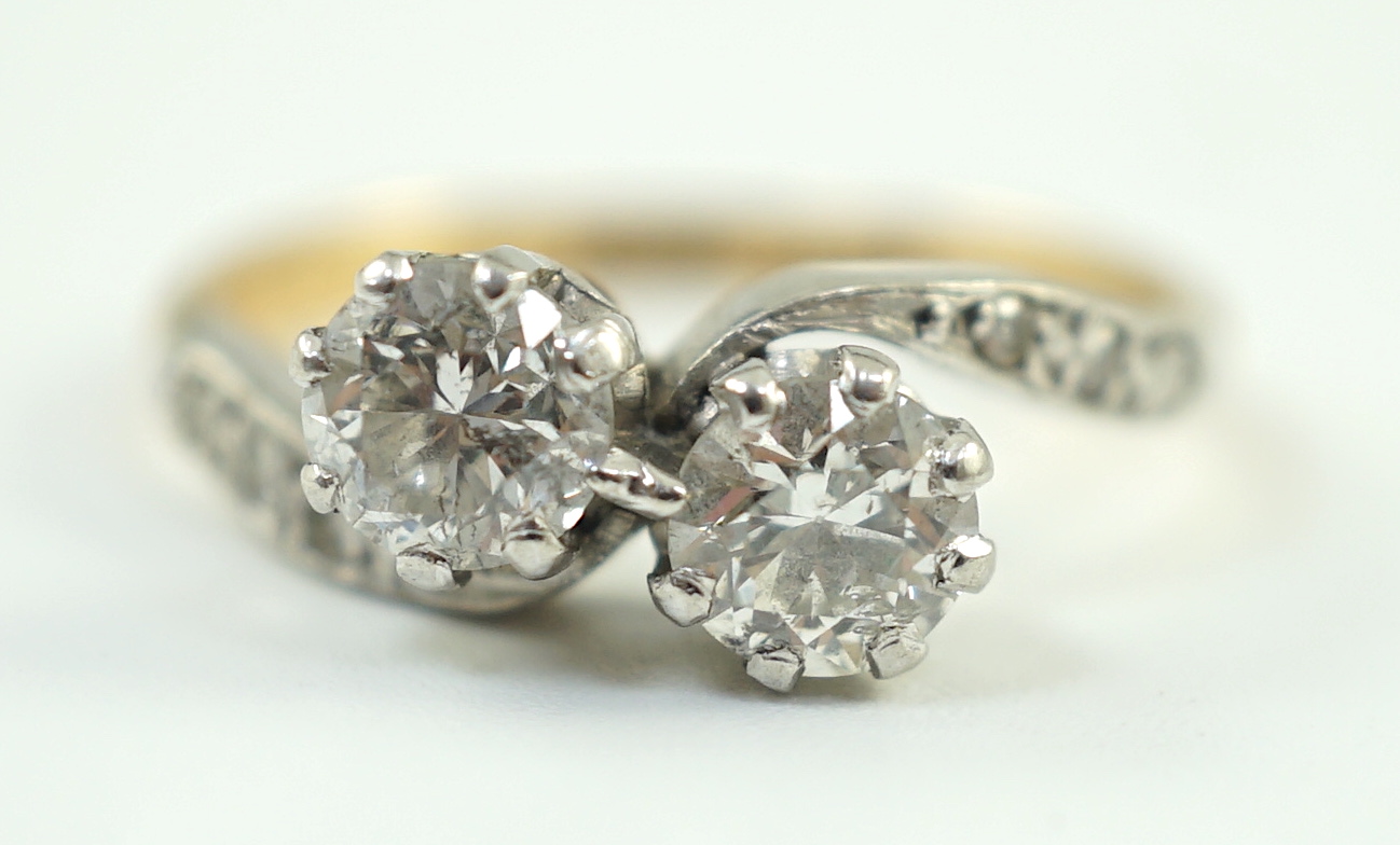A mid 20th century 18ct gold, platinum and two stone diamond set crossover ring